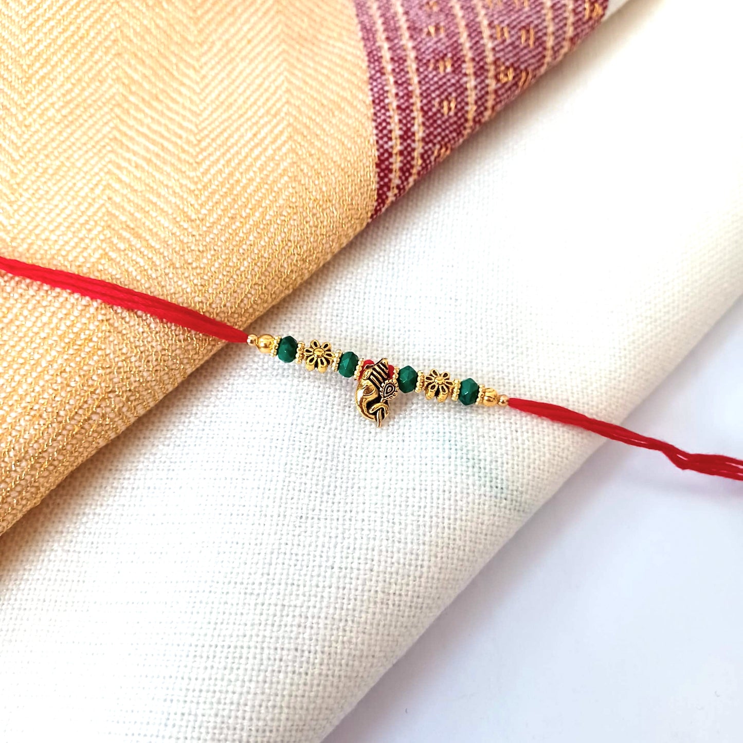 Floral Gold Rakhi On A Red  Thread